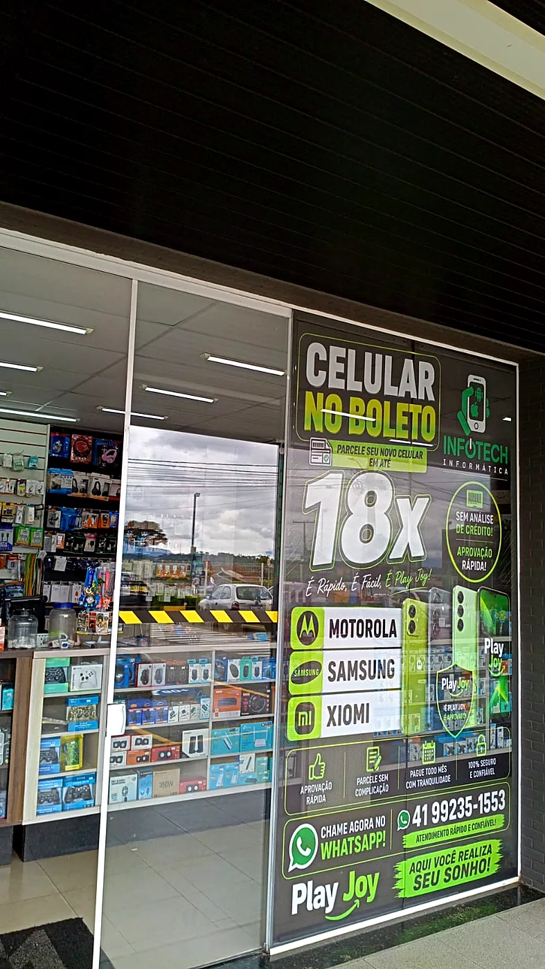 Fachada de vidro da Infotech com o adesivo Celular no boleto em até 18x e as marcas Motorola, Samsung e Xiaomi