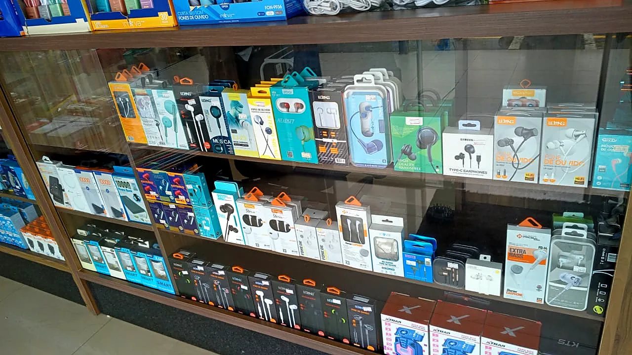 Prateleira com fones de ouvido com fio e power banks embalados